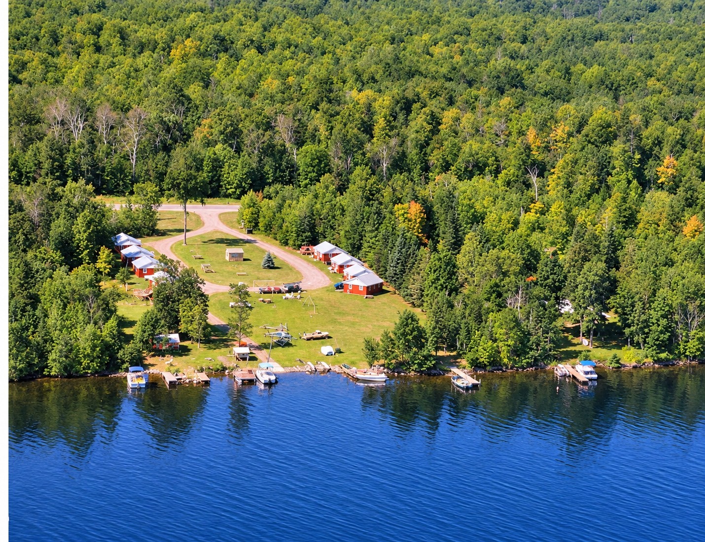 Aerial view of West Shore Resort cabins, lawn, docks, and boats on the Lake Gogebic shoreline
